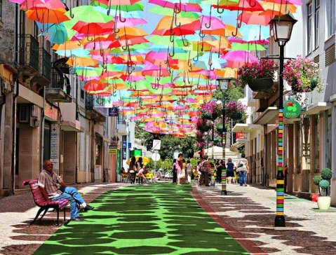 A colorful canopy of umbrellas, a part of the Agitagueda art festival in Águeda, Portugal. Photo by Patrícia Almeida