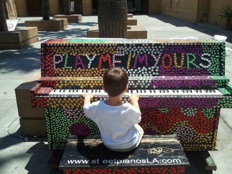 Future pianist plays at a street piano near the Egyptian Theater. Photo by Adam Winter via streetpianos.com